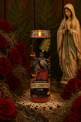 Candle with a figurine of a woman in a white robe and red roses on a wooden background