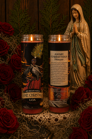 Two candles with labels and a statue of a religious figure on a decorative background with red roses.
