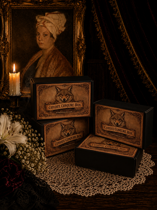 Set of 'Coyote Conjure Box' with a vintage portrait and candle in the background