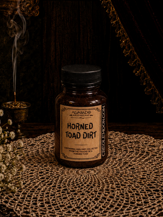 Jar labeled 'Horned Toad Dirt' on a textured surface with a dark background