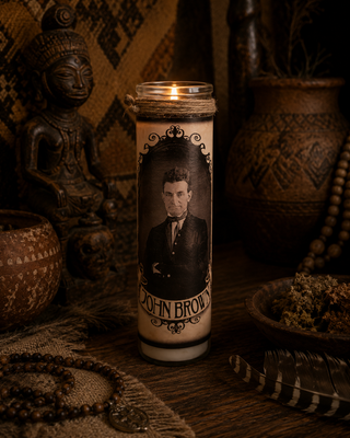 Candle with a portrait of John Brown on a dark background