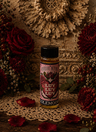 Bottle of 'Voodoo Mama' LUV LUV LUV oil with decorative flowers and lace in the background