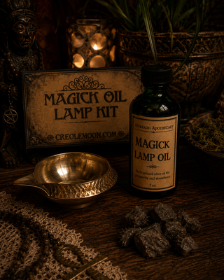 Bottle of Magick Lamp Oil with a sign labeled 'Magick Oil Lamp Kit' on a dark background.