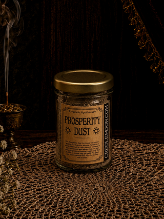 Jar labeled 'Prosperity Dust' on a textured surface with dark background