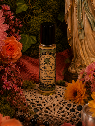 Bottle of Sweet Tea perfume surrounded by flowers and decorative elements