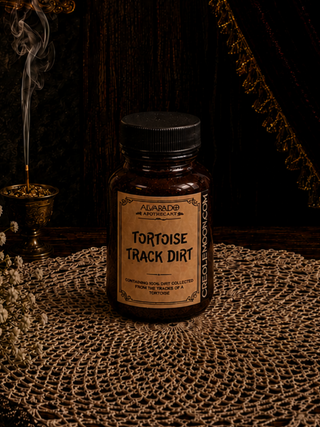 Bottle labeled 'Tortoise Track Dirt' on a textured surface with a dark background
