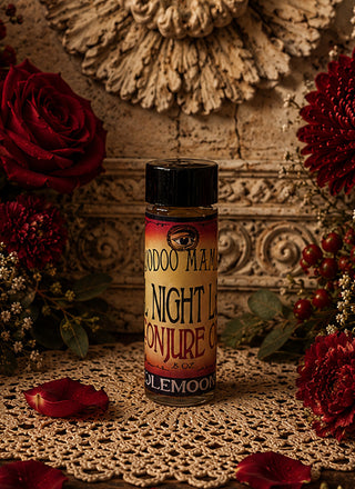 Bottle of All Night Long conjure oil on a decorative surface with flowers and intricate background